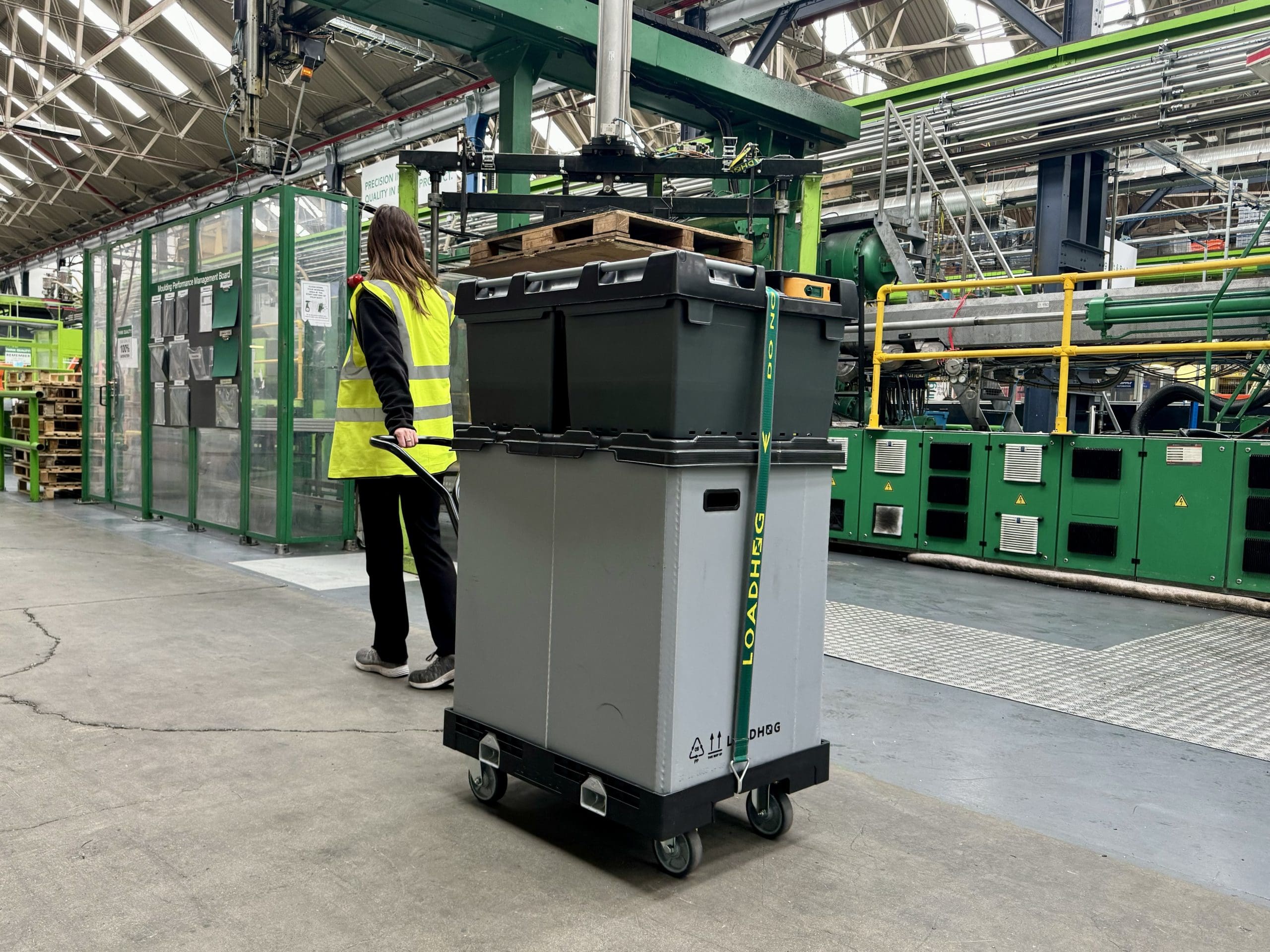 warehouse operative pulling large container system in supply chain