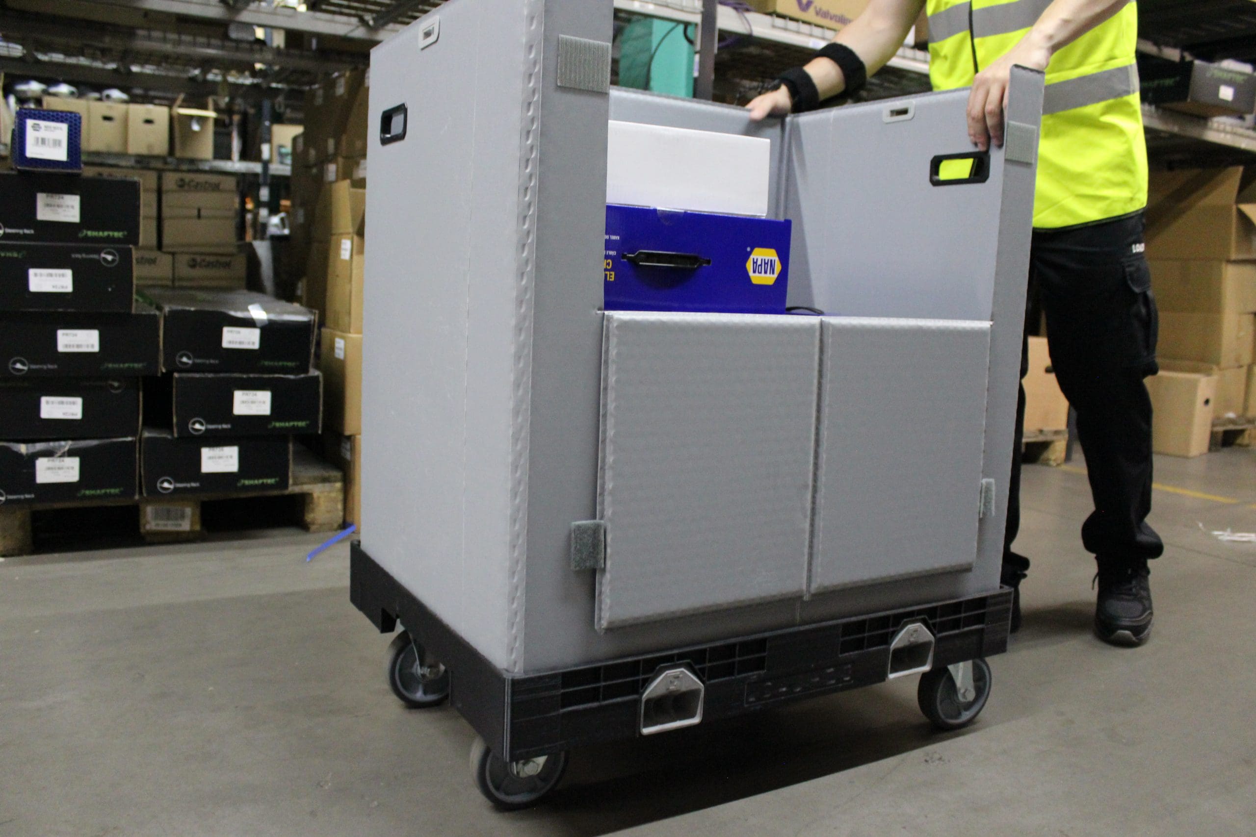 large wheeled container being pushed in automative warehouse